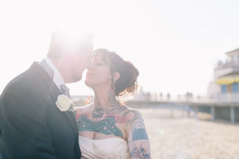 Cumberland Hotel Wedding Photographer bride and groom kissing in sunlight by bournemouth pier