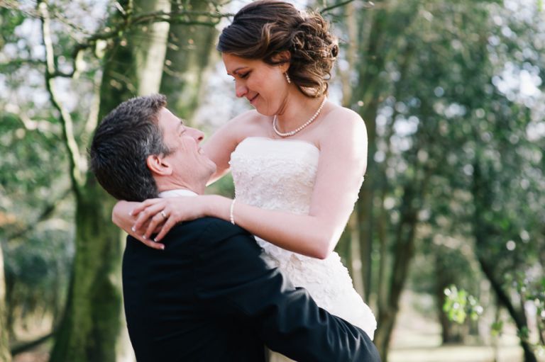 rhinefield house hotel hampshire wedding photographer groom lifting his new bride up