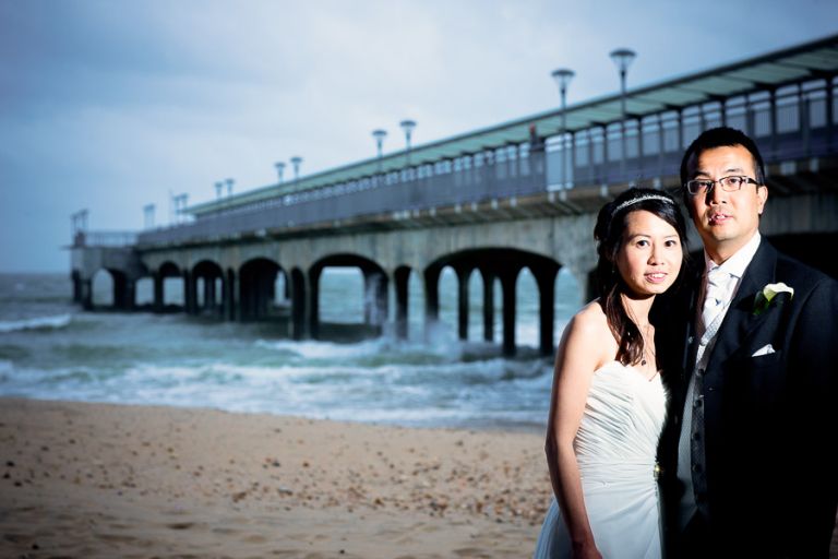 Bride and groom wedding portraits by the pier at Bournemouth Beach