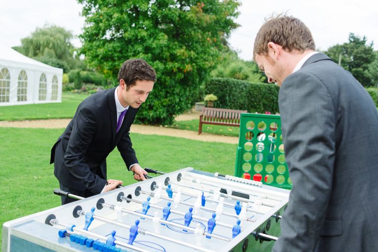 weddings-at-deans-court-wimborne-wedding-photographer-guests playing table foosball