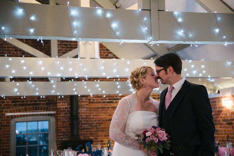 Jo and Andy dinosaur themed winter wedding at sopley mill kissing