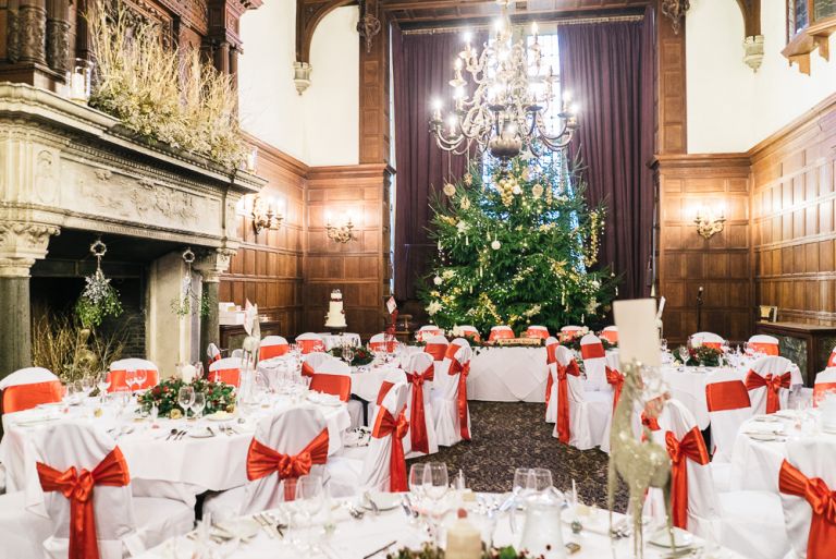 Wedding breakfast ready setup for christmas wedding with big christmas tree