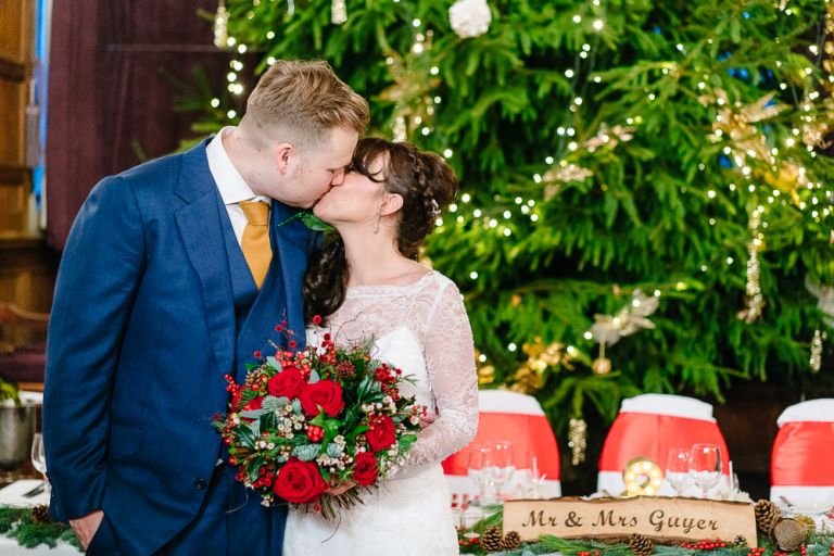 Tim and Claire kissing in front of Rhinefields House huge Christmas Tree