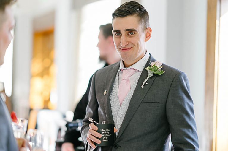 groom showing his hip flask at the balmer lawn hotel at a wedding