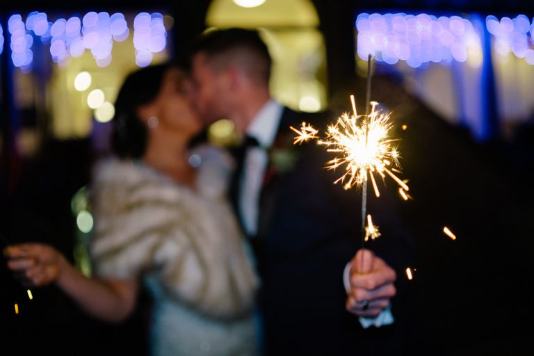 katy and barny holding sparklers outside the italian villa